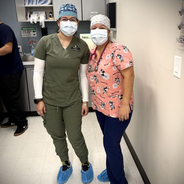 Two vet staff wearing masks and scrubs